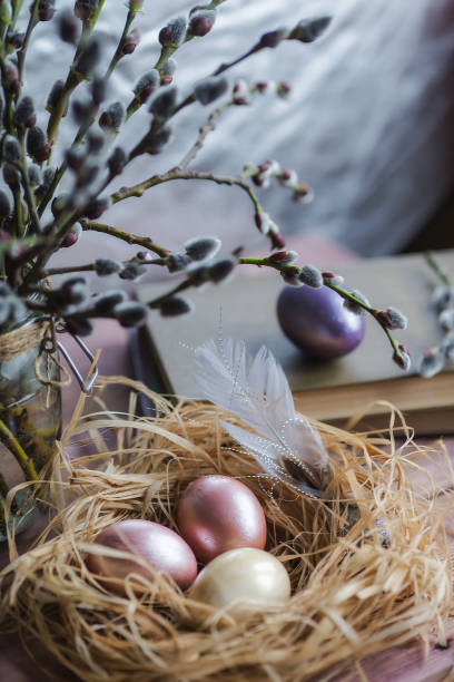 istock Pink and yellow Easter eggs in nest on wooden background.  Minimal easter concept. Easter card with copy space for text. 1388901954