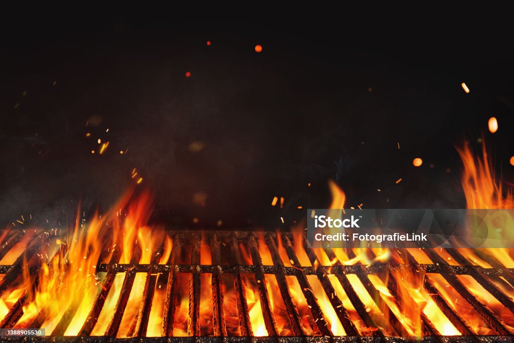 Fire embers particles over black background.  Grill Background - Empty Fired Barbecue On Black . Abstract dark glitter fire particles lights. Barbecue Grill Stock Photo