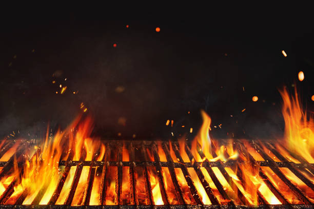 Fire embers particles over black background.  Grill Background - Empty Fired Barbecue On Black . Abstract dark glitter fire particles lights. stock photo