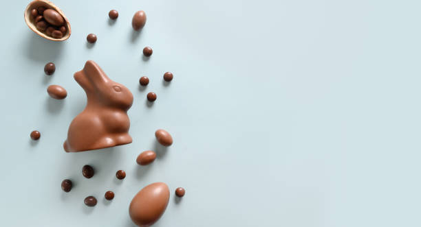 Happy Easter greeting card with chocolate sweets rabbit, eggs. Concept egg hunt. Happy Easter greeting card with chocolate sweets rabbit, eggs on blue background. Concept egg hunt. chocolate bunny stock pictures, royalty-free photos & images