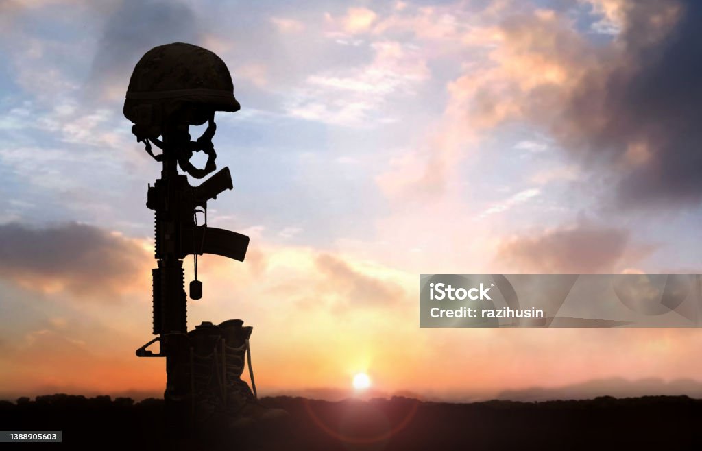 Fallen Soldier background concept with military helmet boots and rifle Helmet Stock Photo