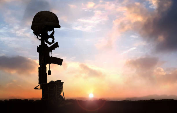 fallen soldier background concept with military helmet boots and rifle - capacete imagens e fotografias de stock