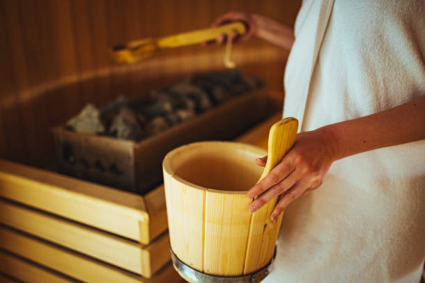 istock Beautiful woman adding steam at the sauna 1388906863