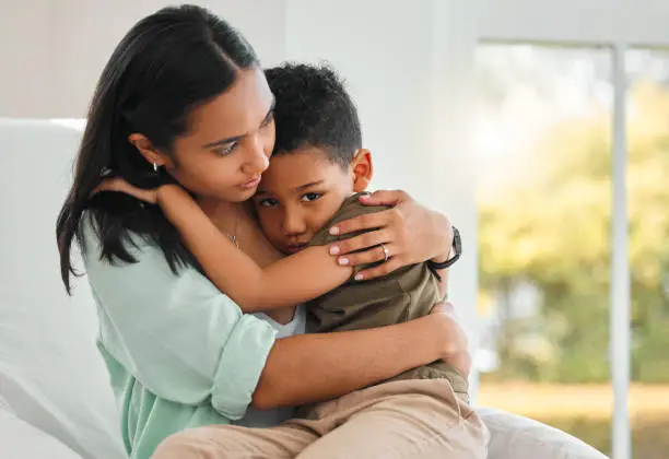 Photo of Shot of a young mother holding her sick little boy at home