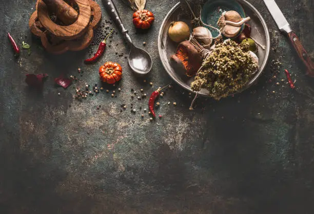 Dried  herbst and spices rustic food background with spoon and  knife , top view.