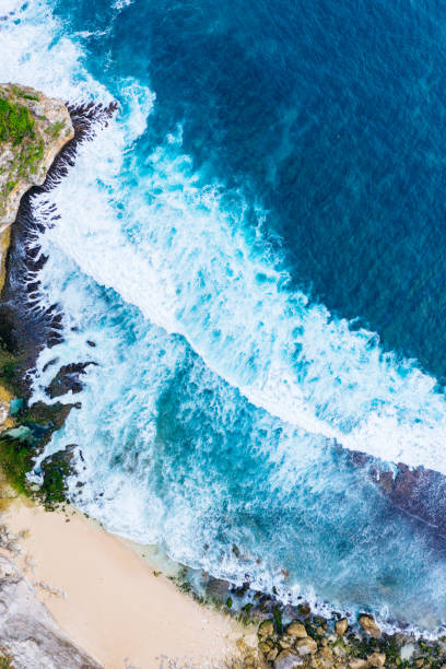 istock Ocean waves hitting a rocky beach. View from above. 1388911492