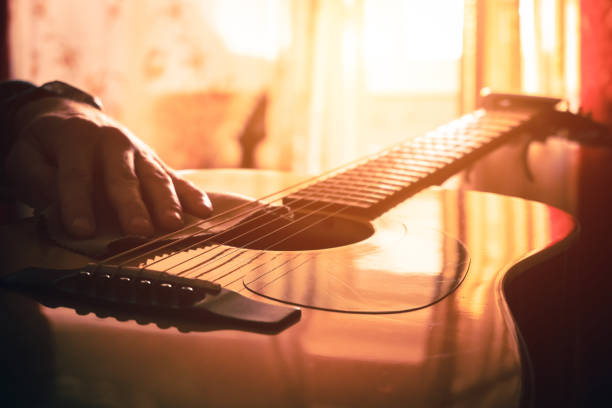 istock A young man is dusting his guitar. close-up. Sun rays 1388911669