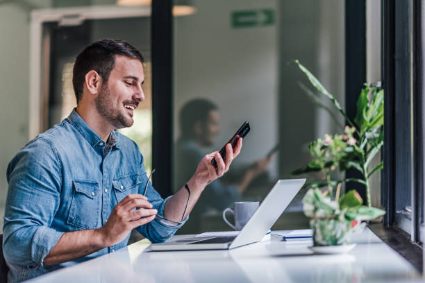 istock Relaxed business man, preparing to dial a phone number. 1388911928