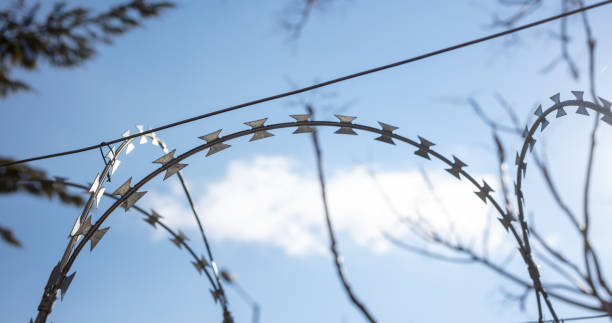 istock Barbed wire fence against sky 1388911935