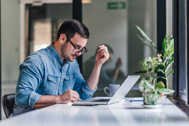 istock Attractive adult man with glasses, completing his tasks at work. 1388911991