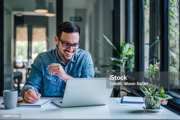 Lovely Business Man Attending A Meeting Online Writing Stuff Down Stock Photo - Download Image Now