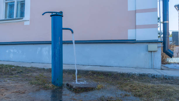 street old and mechanical water tap. water source in the city. iron faucet for drinking water in a public place. - well fountain water pipe pipe imagens e fotografias de stock