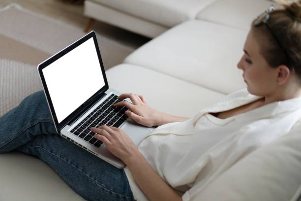istock Mockup image of a woman using and typing on laptop computer keyboard with blank white desktop screen. 1388918165