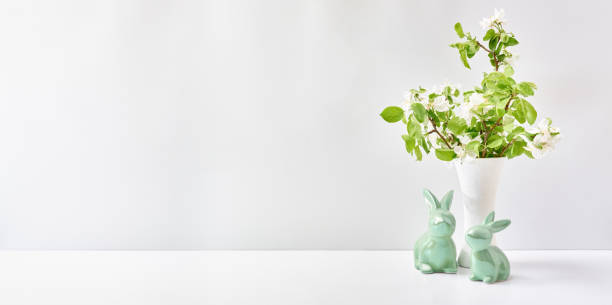 istock Spring flowers in a vase, easter bunnies on a white table. Easter background with copy space 1388918270