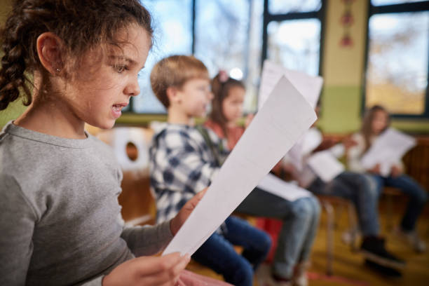istock Schoolgirl practicing with sheet music on a class at school. 1388919467