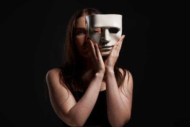 istock Studio shot of a woman hiding behind a blank mask 1388920995