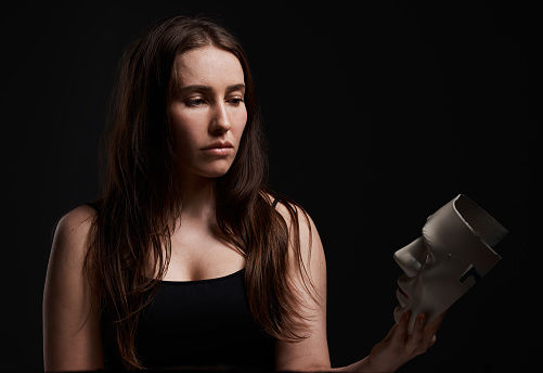 Studio shot of a woman holding a mask