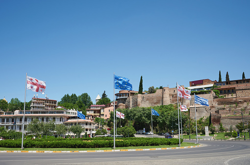 Round square with EU and Georgian flags on bright sunny day