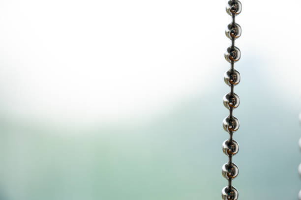 Close up a metal chain of a roller blind with blurred background for copy space