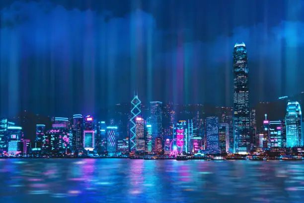 Cityscape of Hong Kong city skyline at night over Victoria Harbor with reflecting in harbour, Cyberpunk color style