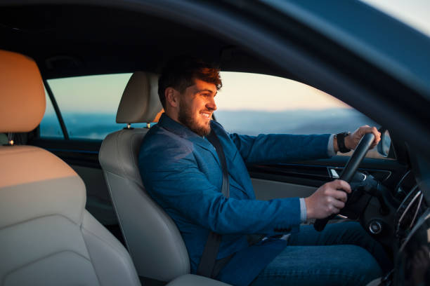 istock Businessman driving his car on sunset. 1388922519