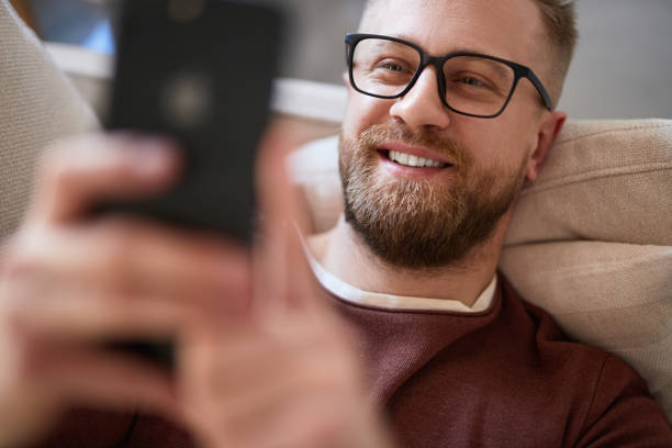 Content man taking selfie on smartphone at home