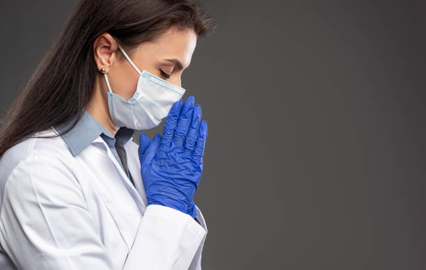istock Female doctor praying during pandemic 1388922732