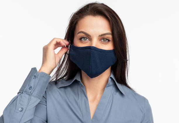 istock Female patient putting on fabric mask 1388922748