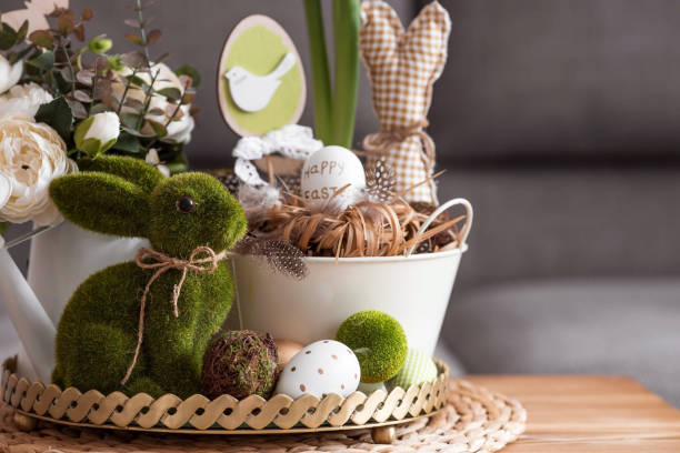 istock Rustic. White-green colors. Iron planters with Easter eggs, flowers, candles and rabbits in the living room interior on the table. The concept of home comfort in the bright holiday of Easter 2022. 1388923100