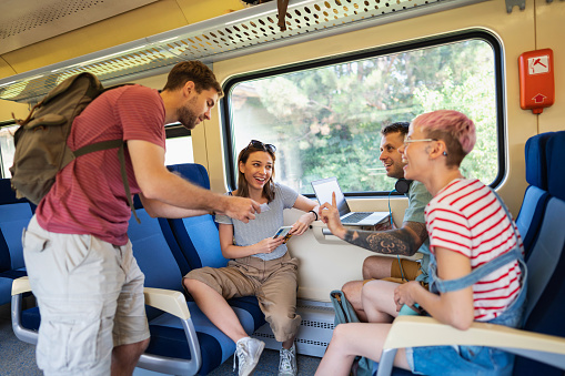 At the train, carefree Caucasian male and female friends travel together