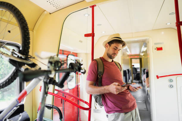 istock Caucasian male tourist, using mobile phone while travel in the train 1388923618