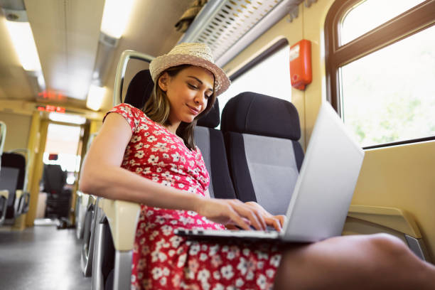 istock Female tourist working on laptop while travel with train 1388923663