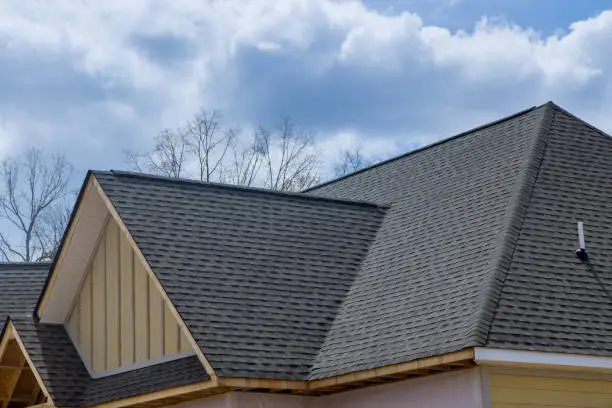 Photo of Asphalt shingles roofing construction waterproofing for house asphalt shingles corner