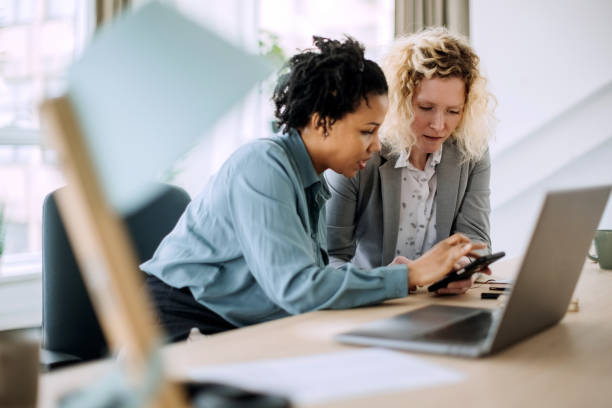 Two diverse businesswoman working together in office stock photo