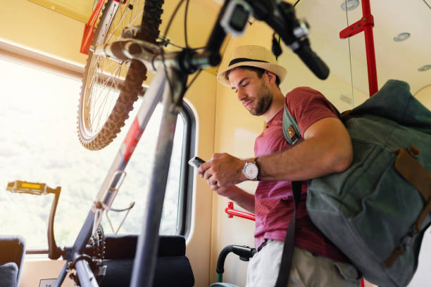 istock Caucasian male tourist, using mobile phone while travel in the train 1388925101