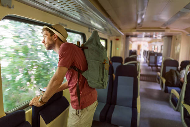 istock Caucasian male tourist looking through window, while travel with train 1388925104