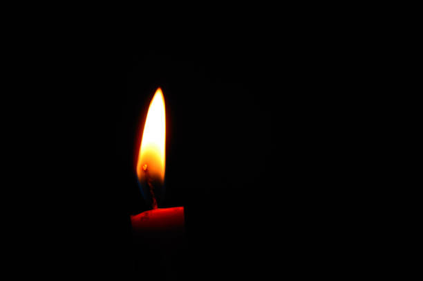 istock red candle on a bldetail view from a red burning candle in the black night during war 1388925529