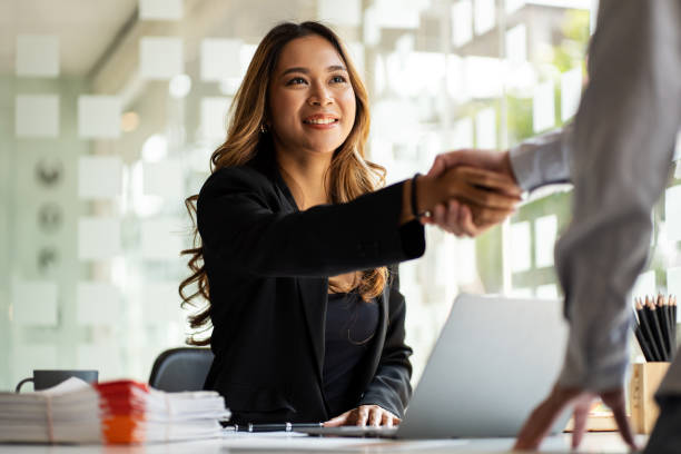 estrechando la mano para una entrevista de trabajo de una joven mujer de negocios asiática en una oficina moderna. concepto de trato de saludo. - opportunity handshake job business fotografías e imágenes de stock