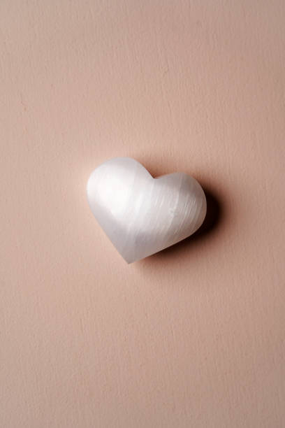 istock Heart shaped crystal stone on pink background 1388926348