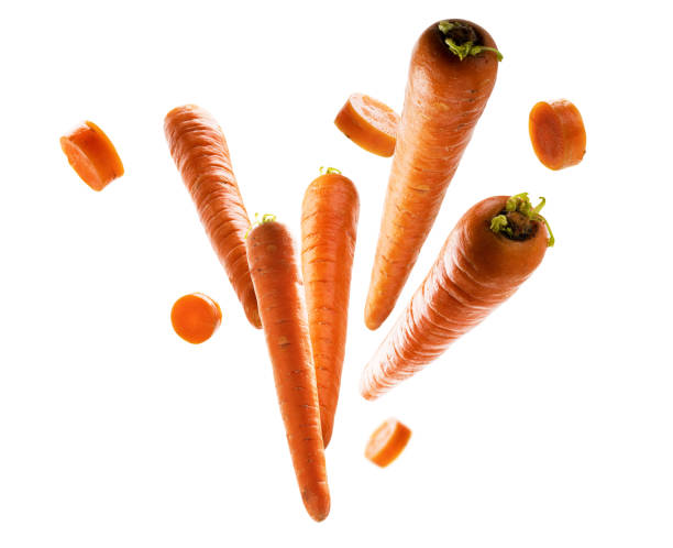 Ripe carrots whole and sliced levitate on a white background stock photo