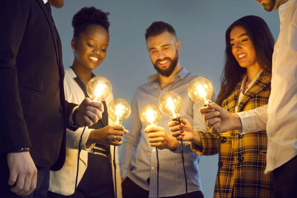istock Diverse business team joining shining light bulbs as metaphor for sharing creative ideas 1388927126