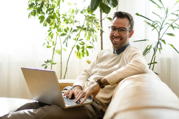 istock Smiling man working from his living room 1388928494