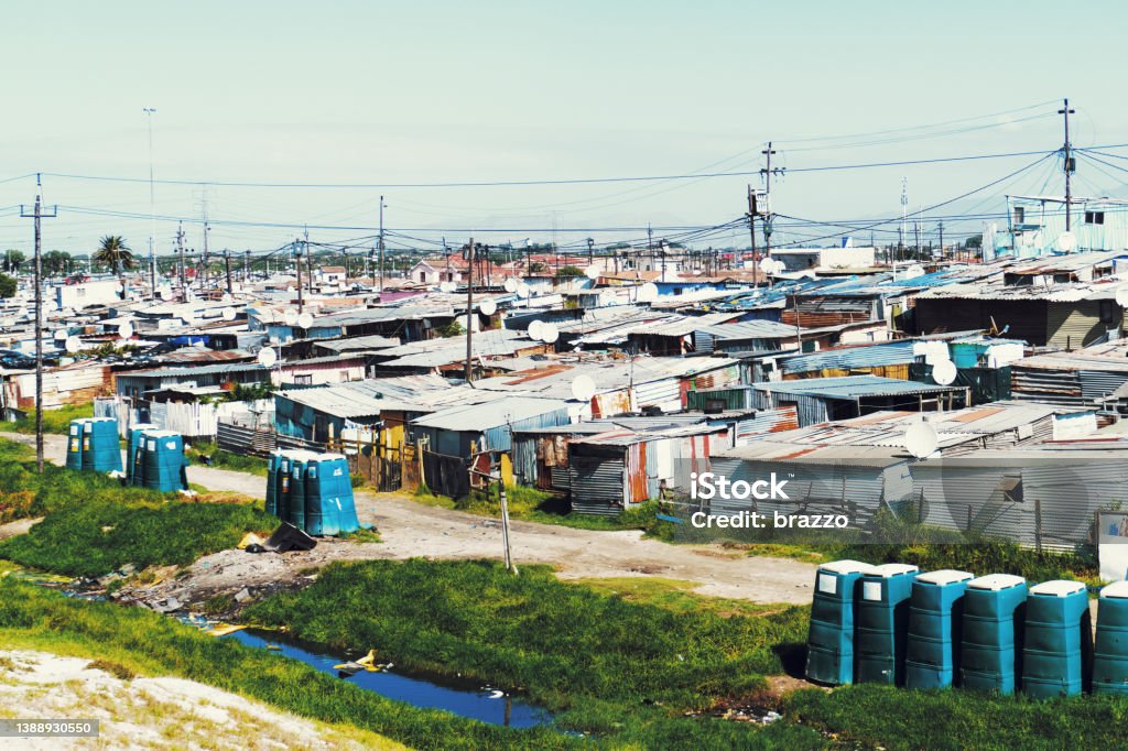 Shack homes in a ghetto Roof tops of shack homes in a ghetto with electricity power lines South Africa Stock Photo