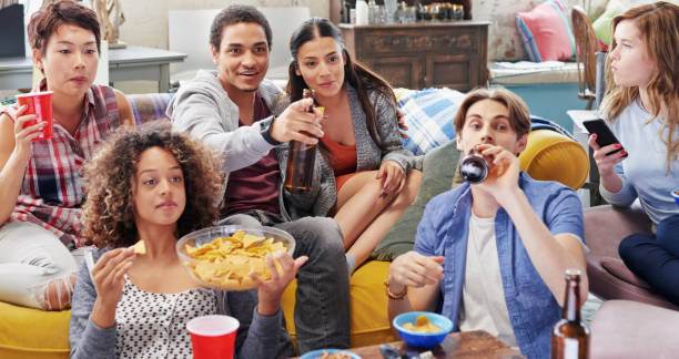 istock Shot of a group of friends enjoying snacks and drinks while watching something 1388931891