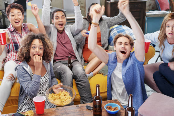 istock Shot of a group of friends enjoying snacks and drinks while watching something 1388931893