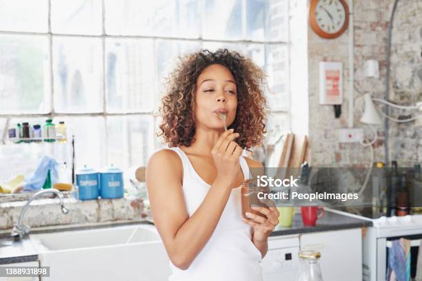 Shot Of A Young Woman Eating A Chocolate Spread From The Jar Stock Photo - Download Image Now