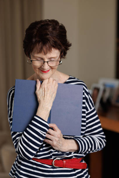istock Smiling woman at home holding a book 1388934267