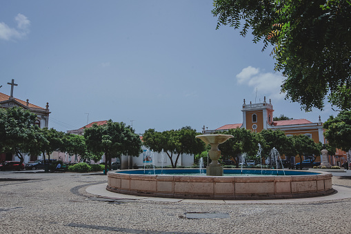 Praça Alexandre Albuquerque park in the capital city of Praia on Cabo Verde islands and beautiful fountain on a warm summer day.