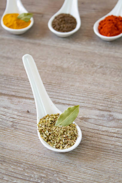 istock Oregano in a white ceramic spoon on wooden background, selective focus 1388936387