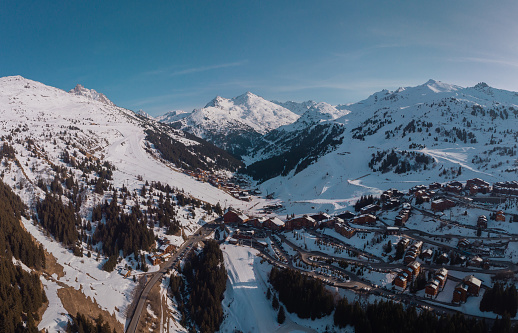 Wide Aerial panorama of Meribel village, on the end of the valley in the french Alps. Beautiful panorama of ski slopes and chalets with alpine background.